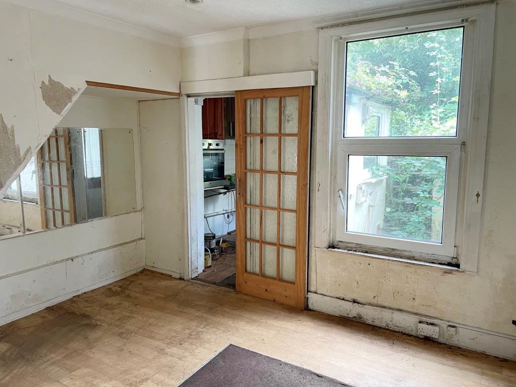 Lot: 4 - TERRACE HOUSE IN NEED OF REFURBISHMENT - Rear dining room with door to kitchen